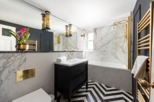 Bathroom with bath and overhead shower in Sky View Brunswick Square Holiday Let Apartment